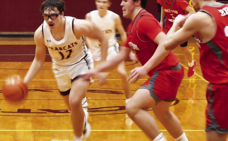 Webster Area Bearcats boys basketball took on the Britton-Hecla Braves Dec. 20 in a contest the Bearcats lost 46-56. Here, Webster Area forward Jeron McCreary (12) drives to the paint with Britton-Hecla defenders Graham Fosness (15) and Daniel Person (20) attempting to impede his route to the basket. Reporter &amp; Farmer | Brenner Cariveau