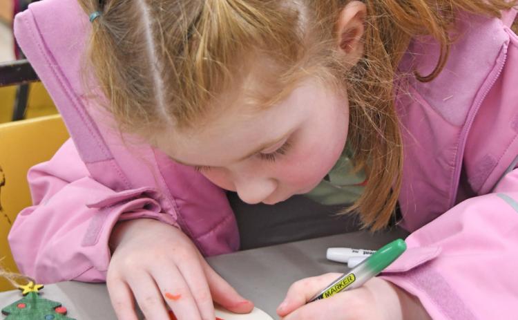 Reporter &amp; Farmer Amanda Dulitz At right Four-year-old Iyla Warner colors a wooden Christmas tree ornament Dec. 1 at the Day County Arts Center in Webster during a community event held there. Warner is the daughter of Mia Hannan and Cody Warner.