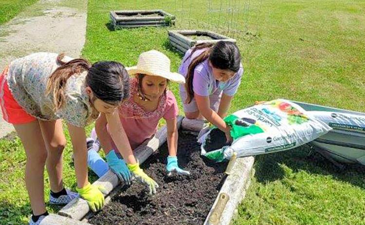 Students of the Toka Nawan Wayawa Tipi (translation: Enemy Swim Day School) Out of School Time program work on planting a garden at the school, located north of Waubay. Pictured from left are Marvalynn Redday, Amelia Simon and Mahpiya Gill. Reporter &amp; Farmer | Subscriber snapshot