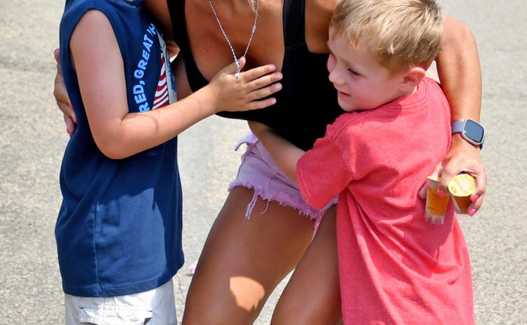 Taking a quick break from filling their candy bag in order to hug their “auntie” during the Waubay Fun Fest parade July 20 is six-and-a-half-year-old Owen Brantl (left) and brother four-year-old Colson Brantle (right) as they share a moment with their aunt Teresa Grebner who walked in the parade. The boys are sons of Jake and Amanda Brantl. Reporter &amp; Farmer | Amanda Dulitz