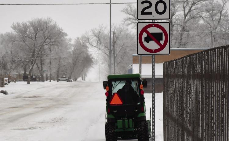 Monty Bloom removes snow with his garden tractor as he drives down W. 6th Ave. past the Main St. intersection clearing snow in his path on the sidewalks Dec. 2. Reporter &amp; Farmer | Brenner Cariveau
