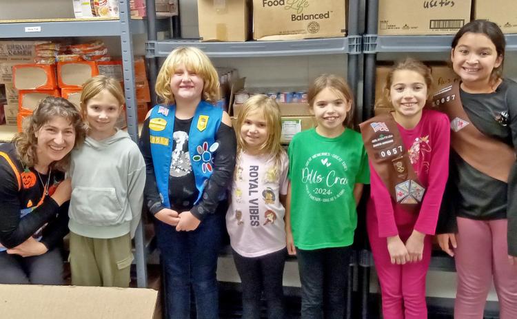 Members of Girl Scout troop #50657 of Webster spent a portion of their evening Oct. 30 packing food for the PACH (People Against Child Hunger) program at the Day County Food Pantry. Pictured from left are troop leader Jennifer Moos, Olivia Ewing, Faith Gaikowski, Arabella Ewing, Finley Marko, Aly Moos and Amara Pool. Reporter &amp; Farmer | Jessica Washenberger