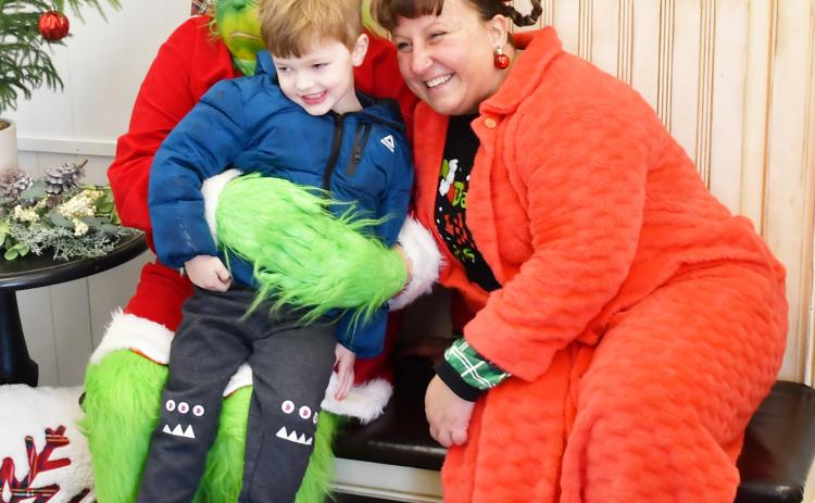 Four-year-old Griffin Lynde sits on the lap of the Grinch who made an appearance at the Brewhouse Dec. 21, along with Whoville resident Amanda Dohn. Lynde is from Webster and is the son of Matt and Megan Lynde. The event was part of a fundraising competition between the Grinch and Santa to see who could raise the most funds for six-year-old Jadyn Campbell who had open heart surgery Dec. 4.