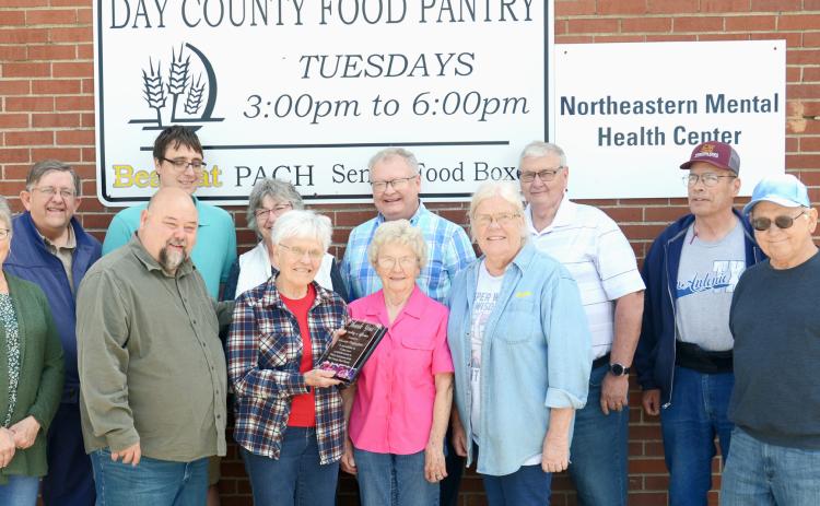 On her final day of volunteering at the Day County Food Pantry May 28, Louise Grajczyk was surrounded by coworkers-turned-friends who included fellow volunteers and area pastors. From left in back is Mike McCarlson, Tim Martin, Mary Wagner, Mike DeKraai, Lynn Lutz and Rick Hanson; from left in front is Susie Hanson, Clark Audiss, Louise Grajczyk, Carol Richardt, Winneva Jacobs and Denny Dugaard. Reporter &amp; Farmer | Annie Witt