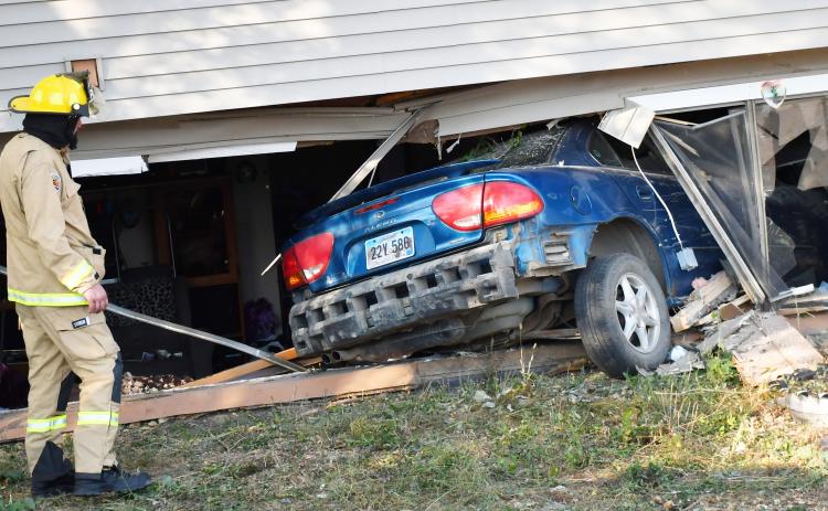 A fireman looks on towards the destruction after a car crashed into a Bristol apartment’s living room Oct. 9. According to Bristol Fire Chief Preston Hansmeier, the driver sustained the only injury during the incident. No cause has been found, Hansmeier said. Reporter &amp; Farmer | Brenner Cariveau