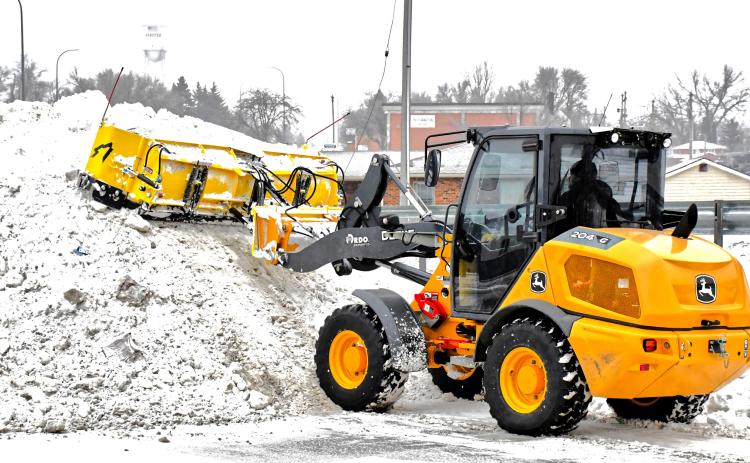 Avery Wyffels operates a piece of snow removal equipment Dec. 31 and piles snow in the back corner of a Webster business parking lot. He also helped move snow off roadways so drivers could motor safely following last week’s snowfall event. Reporter &amp; Farmer | Connor Handrahan