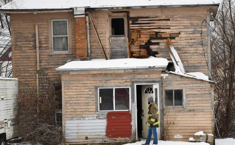 Firefighters revisited the 1106 Main St. house Dec. 10 accompanied by the Day County Sheriff and other men in hazmat suits. Fire Chief Robert Kwasniewski said no comment was available about the house due to the ongoing investigation. Here, Chris Gravley waits outside the back door during the visit of the home. The Main St. house was originally a part of a fire Sept. 9 with the cause of the fire never officially released. Reporter &amp; Farmer | Brenner Cariveau