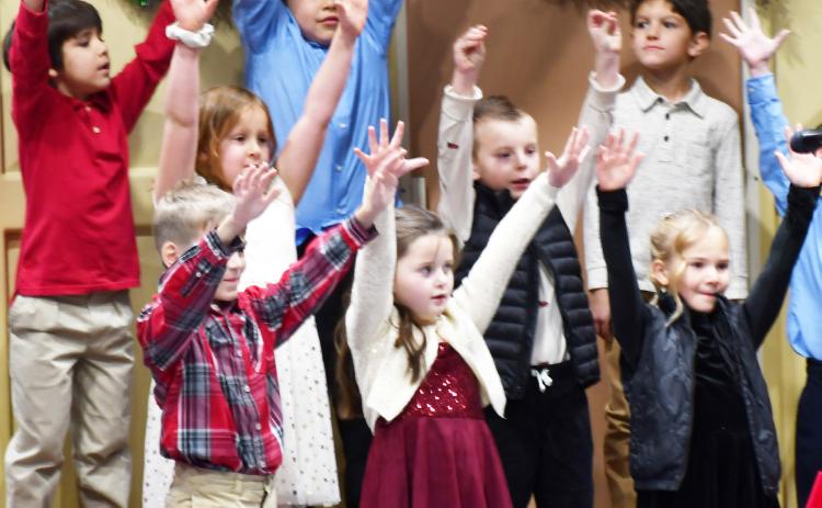 Webster Area Elementary grades k-6 participated in te winter concert at the Webster Armory Dec. 9. Here, first grade students reach towards the sky as part of their singing routine. Pictured from lef in back row are, Frank Clemente, Hunter Fellbaum, Cody Carey; second row from left, Brooklyn Bohnenkamp, Nolan Curran; first row from left Ethan Haabala, Mavis Stoebner and Arabella Ewing. Reporter &amp; Farmer | Brenner Cariveau