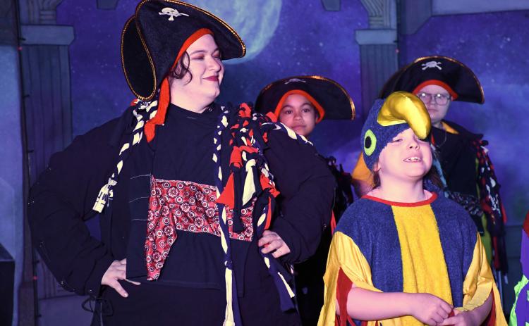 Webster Area first grader Vivian Garry, right, plays a parrot next to Theatre 605 actor/director Nessa Yaakova who plays a pirate during the school’s musical production of Space Pirates March 13 at Webster Area High School. The play was Webster Area’s sixth time hosting the touring theatre company who helps students put on a production with one week of preparation. Reporter &amp; Farmer | Leyton Beardslee