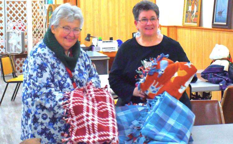 Blankets were tied at Day County Arts Center Christmas tree lighting event in Webster Nov. 30. Here, from left, Darlene Dulitz and Tandra Smidt announced the blankets will be donated to Sanford Hospital for people who need some way to stay warm during the cold winter. Reporter &amp; Farmer | Connor Handrahan