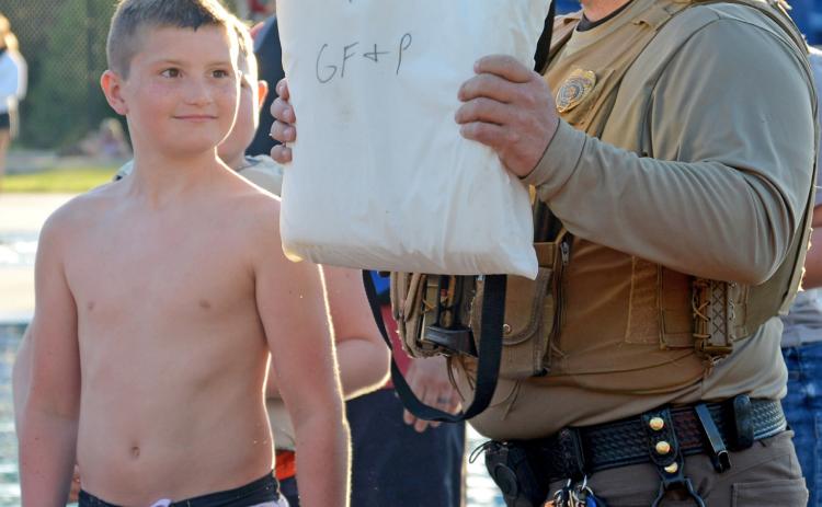 Conservation officer Austin Norton explains a throwable flotation device to the group with volunteer Cruz Schafer at the Thrivent water safety event June 13. Reporter &amp; Farmer | Annie Witt
