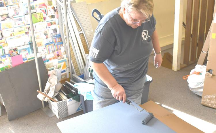 Needs Anonymous thrift store is undergoing renovations with the intention of re-opening March 29. Here, volun-teer Cathy Witzke helps paint shelving for the store March 12. Reporter &amp; Farmer | Brenner Cariveau