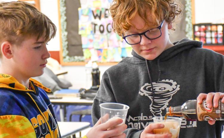 Webster Area eighth grade students, from left, Harley Valley and Casen Fish make root beer floats Feb. 2 at Webster Area Middle School as the class reward for having the highest average attendance for the month of January. Principal Craig Case said this is one change the school has made to help incentivize higher attendance among elementary and middle school students. Reporter &amp; Farmer | Leyton Beardslee
