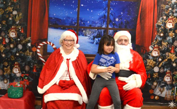 That heartwarming smile a child gets when they see Mr. and Mrs. Claus makes the chaos of the season stop for only a minute. Mr and Mrs. Claus made a stop into Waubay Santa Day. This event was full of family fun with carnival games and bingo, all with prizes the children could win. Pictured are Mr. and Mrs. Claus with Ismeala Strutz, who was pretty excited to see Santa and tell him what she wanted for Chirstmas. Reporter &amp; Farmer | Jessica Washenberger