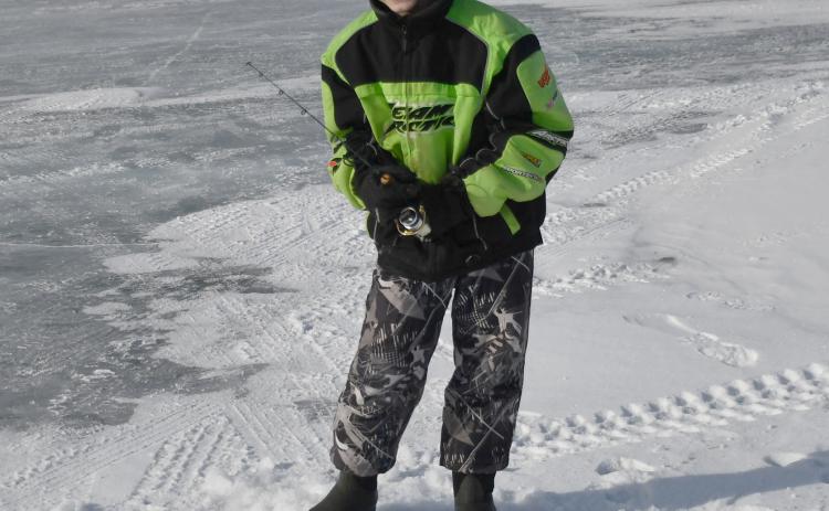 Knights of Columbus hosted the eighth annual ice fishing derby and raffle Feb. 22 at Enemy Swim Lake. Here, 11-year-old Owen Snaza from Webster attempts to catch a fish from an ice hole during the derby. Owen was accompanied by his father Nick Snaza.