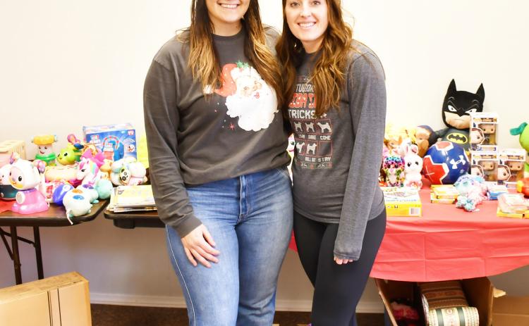 Chelsey Wood and Meagan Baumgarn hosted a free holiday clothing and toy drive at 708 Main St. Dec. 6-7. According to Wood, over eight boxes of donations were recieved from the community. Here from left, Wood and Baumgarn stand in front of a table with children’s toys donated for their drive Dec. 7. Reporter &amp; Farmer | Brenner Cariveau