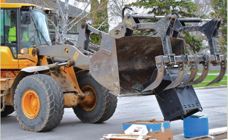 Webster’s annual city wide clean up started April 27. A city crew passed every street and picked up any trash left by residents. Here, John VanBeek operates a loader to pick up a pile of items left on the curb at W. 7th Ave. April 28. Reporter &amp; Farmer | Connor Handrahan