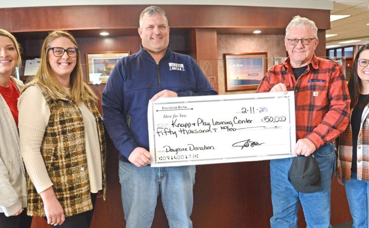 Members of the Knapp &amp; Play Learning Center committee, from left, Lexi Rithmiller and Jenna Wik received a check presented by Joel and Roger Shoemaker Feb. 11. Also pictured is Rainy Hanson with the Webster Area Development Corporation. The Shoemakers made a $50,000 donation towards the Webster childcare center on behalf of their business, Webster Scale. Reporter &amp; Farmer | Amanda Dulitz