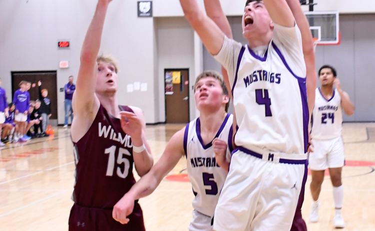Waubay/Summit Mustang Tigh Gaikowski (4) pushes his way past a couple of Wilmot Wolves Jan. 11 to attempt a basket while Mustang Dylan Rumpza (5) looks on. The Mustangs hosted the Wolves in Summit running away with the victory 61-28. Reporter &amp; Farmer | Robert Dulitz