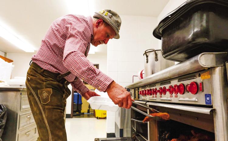 Webster Mayor Mike Grosek takes some schnitzel out of the oven for the traditional German meal served during Germanfest at Webster Armory Sept. 27 (see more on page 14). Reporter &amp; Farmer | Leyton Beardslee