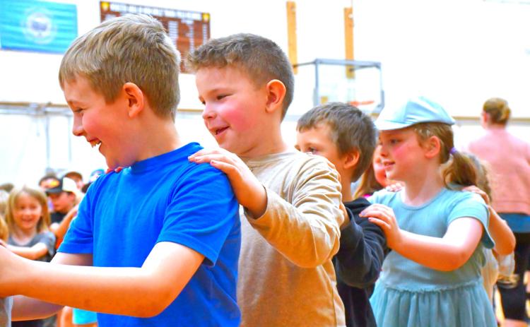 From left, Ronin Smidt, Theodore McDaniel, Bentley Breese and Vivian Garry particpate in the congo line during Phil Baker’s concert at Webster Area Elementary School May 14. Baker performed a variety of songs for the elementary students. Reporter &amp; Farmer | Connor Handrahan