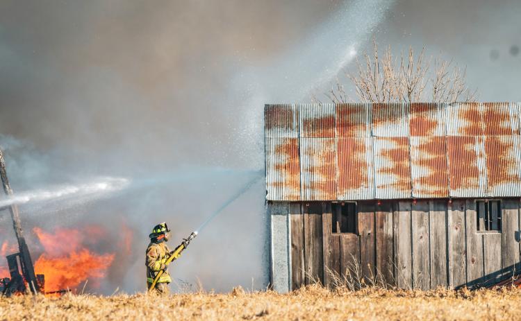 Second assistant fire chief Chris Gravley of Webster Fire Department sprays down a building to keep flames from spreading after a barn fire broke out at 14308 423rd Ave. south of Bristol Jan. 15. Additional details about the fire will be available in next week’s issue. Reporter &amp; Farmer | Leyton Beardslee