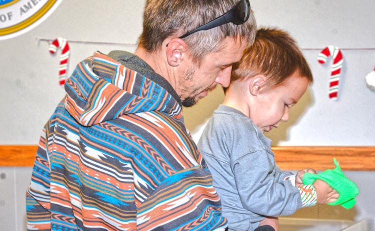 Waubay Senior Center had an inflatable pond for kids to pick out a rubber-duck for a prize at their Christmas celebration Dec. 6. Scott Harrington helped his son Noah Harrington pick out a toy to take home after picking a duck from the pond. Reporter &amp; Farmer | Connor Handrahan