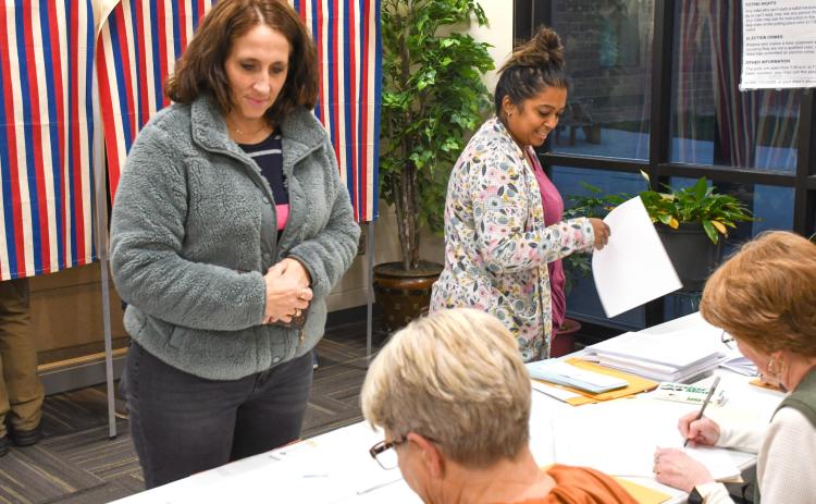 Jami Hubsch, left, and Kaylan Pool, right, each wait in line to cast their ballots Nov. 4 during Webster Area School District’s bond vote. Election officials Sandy Anderson, bottom left, and Bette Zenk, bottom right, helped record each voter who came to the polls that day. The 1,103 voters who cast their ballots represented a 42 percent voter turn out. The $12.5 million bond was ultimately voted down, 682-421. Reporter &amp; Farmer | Amanda Dulitz