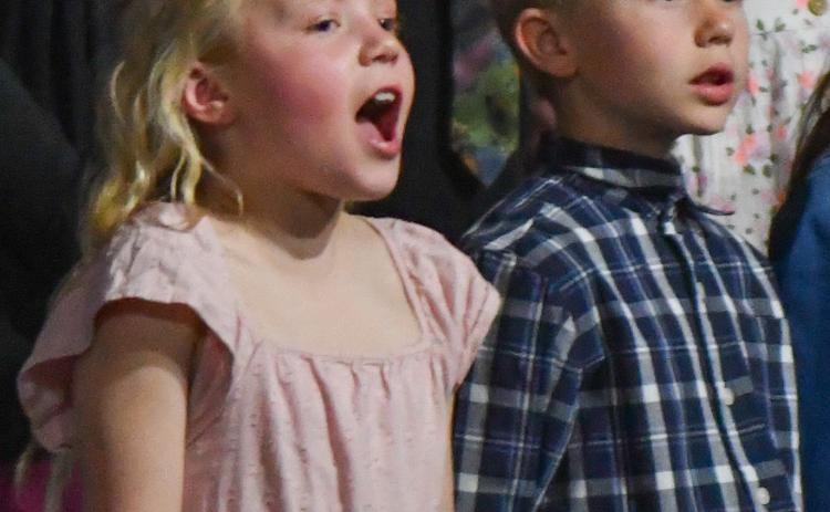 Webster Area Elementary students presented a unique twist to their spring concert April 18 when all students stood up and began singing at the conclusion of the event. Shown here are Adalynn Letcher and Kohenn Konradi, singing “As Long as the World Goes Around” with the entire school’s elementary choir. Reporter &amp; Farmer | Amanda Dulitz
