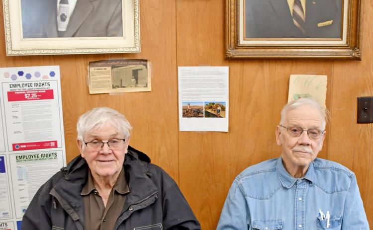 Hansmeier brothers Keith and Floyd sit beneath portraits of their grandfather Henry and father Ralph in the office of Hansmeier &amp; Son, Inc. in Bristol.