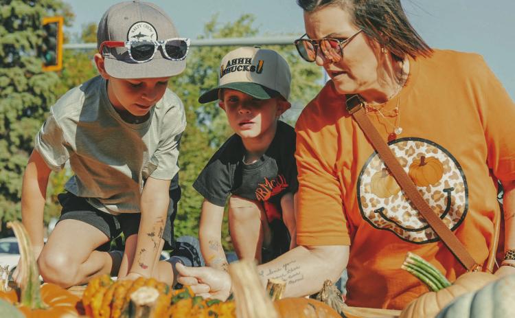 From left, Holden Martin, seven, Layton Martin, three and their grandmother Patti Martin, Webster, pick out pumpkins during Pumpkin Fest in Webster Oct. 4. This year marked the 26th anniversary for the annual festival. Reporter &amp; Farmer | Leyton Beardslee