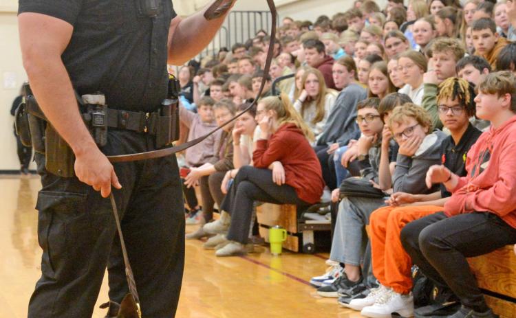 Members of the South Dakota Highway Patrol were at Webster Area High School April 23 to answer questions and hold a demonstration of the drug sniffing dog named Murph, a six-year-old Belgian Malinois. Here, handler Trooper Brandon Miller stands before the assembly of youth answering questions related to his line of work. Both Miller and Murph are from Webster. Reporter &amp; Farmer | Amanda Dulitz