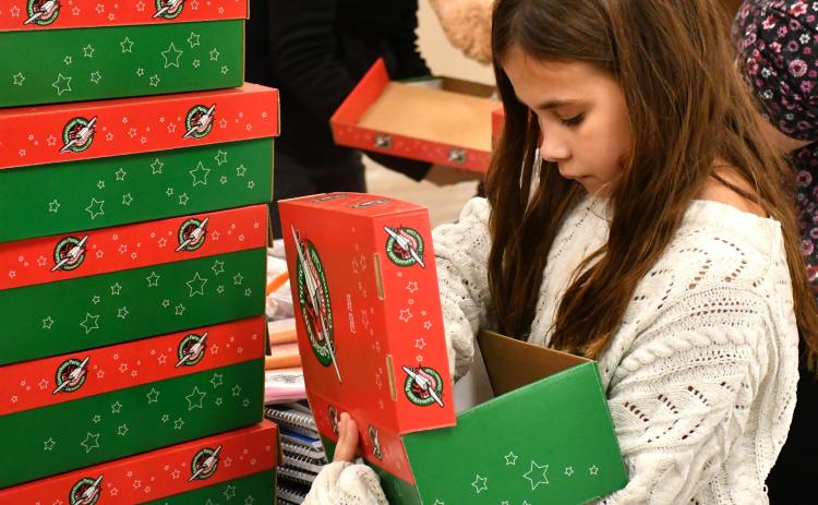 Hattie Miller with Girl Scout Troop 50657 helps pack boxes for Operation Christmas Child at Westside Wesleyan Church in Bristol Nov. 13. Miller is the daughter of Brandon Miller and Sarah Miller of Webster. Reporter & Farmer | Leyton Beardslee