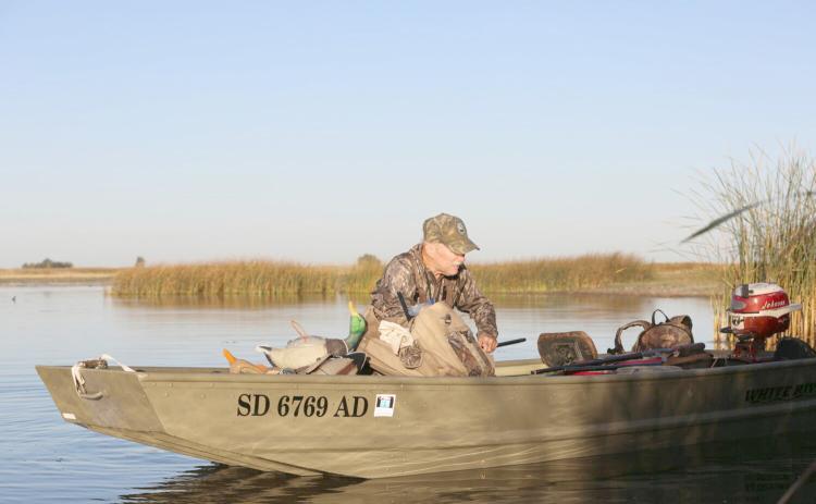 John Cooper moves his duck boat out of the reeds along a northern South Dakota wetland Sept. 27. Reporter &amp; Farmer | Joshua Haiar/South Dakota Searchlight