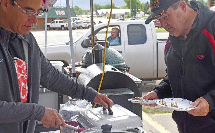 A block party was held June 27 at Webster Ace where the store celebrated the 100th anniversary of Ace Hardeware. Free food was served and activites were held throughout the day. Pictured here, Webster Ace co-owner Alfredo Garduno serves breakfast sausages to Webster community member Dave Fromelt. Reporter &amp; Farmer | Luke Caputo