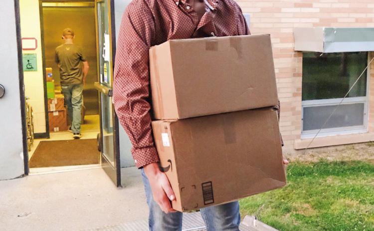Gage Wik, along with other youth from Christ the King Catholic Church, helps load artifacts from the Day County Courthouse Museum into a trailer Oct. 1. The entire courthouse museum will be transported to the Museum of Wildlife, Science &amp; Industry which has built an additional building to house the combination of the two museums. Reporter &amp; Farmer | Leyton Beardslee