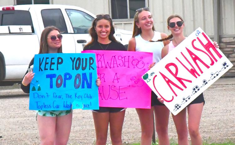From left, Ava Bjerke, Kenslee Zubke, Kinsey Kuecker and Cartney Hanson are waving down cars and advertising for their car wash. Webster Area Key Club hosted a topless car wash June 1 for four hours. Reporter &amp; Farmer | Connor Handrahan