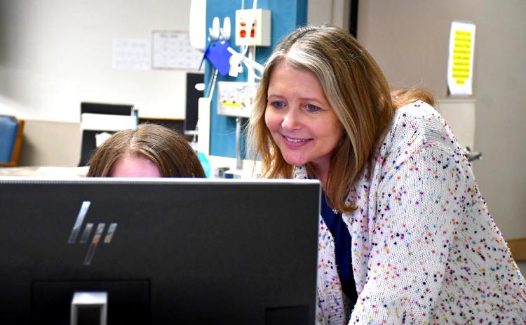 Dawn Rithmiller of Bethesda Home, Webster assists an employee at the nurses’ station April 30. As the director of nursing for that organization, Rithmiller has been given the Leadership of Excellence award from the South Dakota Association of Healthcare Organizations.