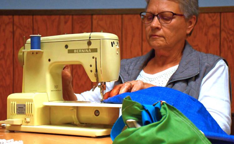 (Above) Sewing with a Purpose is a new group that helps create hygiene bags for young girls in South Africa. Journey of Faith is helping make this project possible and many church members have come to help with it. Here, Judy Williams starts sewing part of a bag’s exterior. Reporter &amp; Farmer | Connor Handrahan